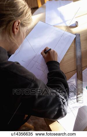 Stock Photography - Female architect drawing plans. Fotosearch