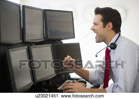 Stock Image - Financial worker analyzing data displayed on computer screen. Fotosearch