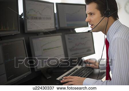 Stock Photo - Financial worker analyzing data displayed on computer screen. Fotosearch