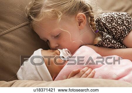 Girl (2-3) embracing baby sister on sofa View Large Photo Image Stock Image - Girl (2-3) embracing baby sister on sofa. Fotosearch