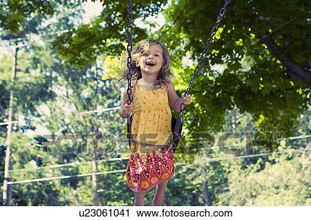 Girl (2-3) on swing in playground View Large Photo Image Stock Image - Girl (2-3) on swing in playground. Fotosearch