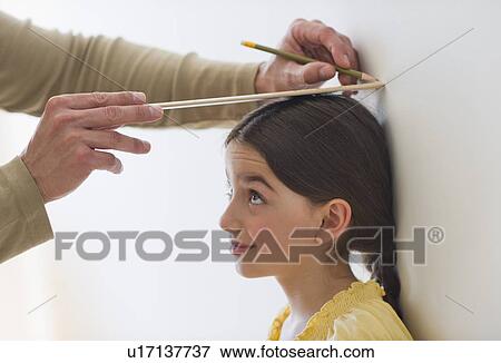 Stock Photo - Girl (8-9) being measured. Fotosearch
