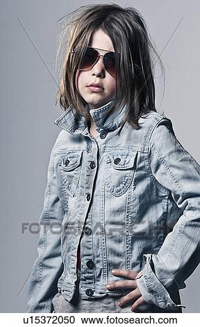 Girl (8-9) posing in oversized denim jacket an sunglasses View Large Photo Image Stock Image - Girl (8-9) posing in oversized denim jacket an sunglasses . Fotosearch