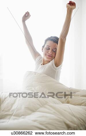Stock Image - Happy young woman waking up. Fotosearch