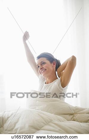 Happy young woman waking up View Large Photo Image Stock Photo - Happy young woman waking up. Fotosearch