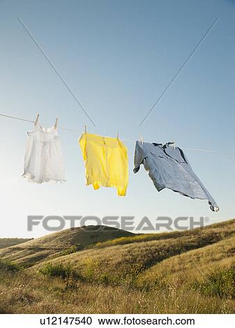 Stock Image - Laundry hanging on clothesline against blue sky. Fotosearch