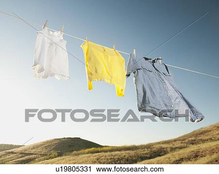 Stock Image - Laundry hanging on clothesline against blue sky. Fotosearch