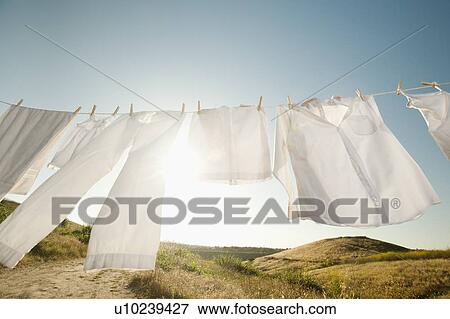 Stock Photo - Laundry hanging on clothesline against blue sky. Fotosearch