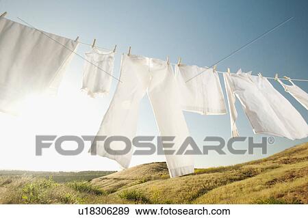 Stock Photo - Laundry hanging on clothesline against blue sky. Fotosearch