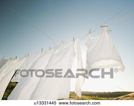 Laundry hanging on clothesline against blue sky View Large Photo Image Stock Photography - Laundry hanging on clothesline against blue sky. Fotosearch