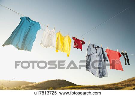 Stock Photography - Laundry hanging on clothesline against blue sky. Fotosearch