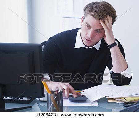 Man doing calculations holding head in hands View Large Photo Image Stock Image - Man doing calculations holding head in hands. Fotosearch