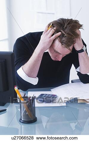 Man doing calculations holding head in hands View Large Photo Image Stock Photo - Man doing calculations holding head in hands. Fotosearch