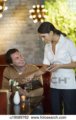 Stock Image - Man ordering food in restaurant. Fotosearch