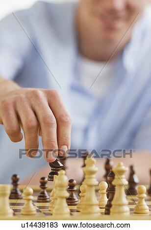 Stock Image - Man playing chess. Fotosearch