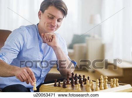 Stock Image - Man playing chess. Fotosearch