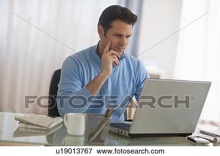 Man using laptop at home office View Large Photo Image Stock Photo - Man using laptop at home office. Fotosearch