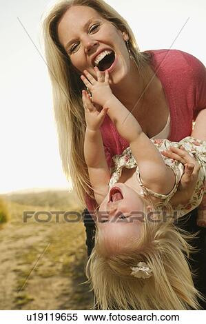Mother playing with daughter (12-17 months) and laughing View Large Photo Image Stock Photography - Mother playing with daughter (12-17 months) and laughing. Fotosearch