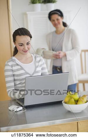 Mother with teenage daughter (14-15) working on laptop View Large Photo Image Picture - Mother with teenage daughter (14-15) working on laptop. Fotosearch