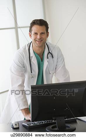 Portrait of doctor working on computer View Large Photo Image Picture - Portrait of doctor working on computer. Fotosearch