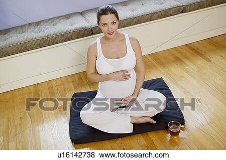 Stock Photo - Portrait of expectant mother exercising. Fotosearch