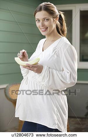 Portrait of expecting mother eating melon View Large Photo Image Stock Image - Portrait of expecting mother eating melon. Fotosearch