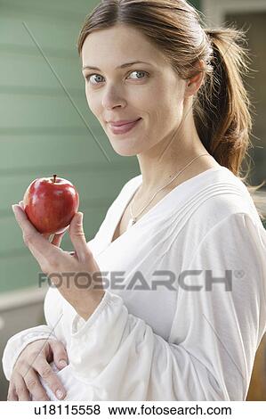 Stock Photo - Portrait of expecting mother eating strawberries. Fotosearch
