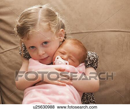 Portrait of girl (2-3) holding newborn girl (0-1months) View Large Photo Image Stock Photo - Portrait of girl (2-3) holding newborn girl (0-1months) . Fotosearch