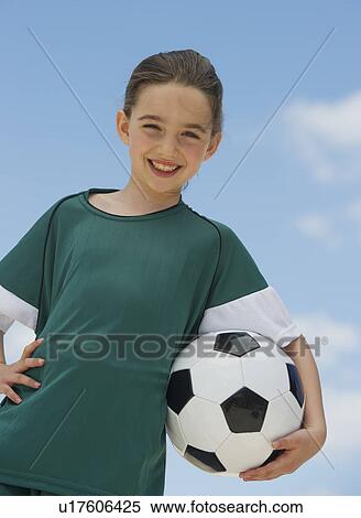Stock Photography - Portrait of girl (8-9) holding soccer ball. Fotosearch