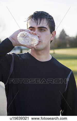 Stock Image - Portrait of man drinking water. Fotosearch
