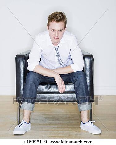 Stock Photo - Portrait of man sitting in armchair. Fotosearch