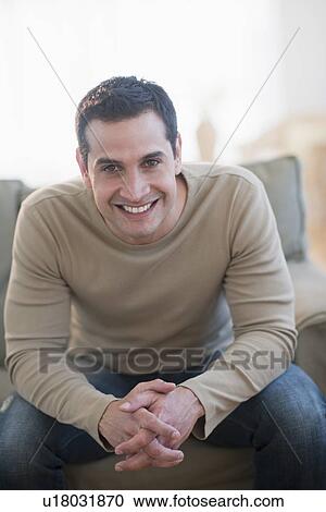 Portrait of mid adult man sitting on sofa View Large Photo Image Stock Image - Portrait of mid adult man sitting on sofa. Fotosearch
