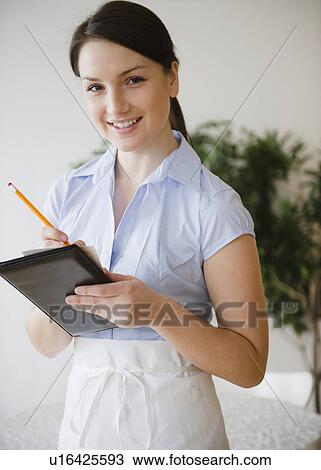 Stock Image - Portrait of smiling waitress taking order. Fotosearch