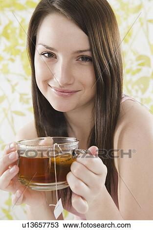 Portrait of smiling young woman holding tea cup View Large Photo Image Stock Image - Portrait of smiling young woman holding tea cup. Fotosearch