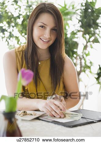 Portrait of smiling young woman paying bill in outdoors cafe View Large Photo Image Stock Image - Portrait of smiling young woman paying bill in outdoors cafe. Fotosearch
