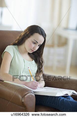 Stock Photograph - Portrait of teenage girl (14-15) doing homework. Fotosearch