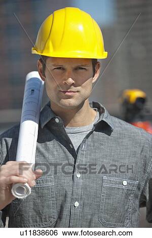 Stock Photograph - Portrait of worker holding blueprint. Fotosearch