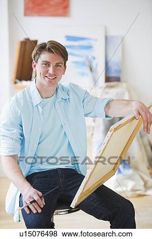 Portrait of young man painting picture in studio View Large Photo Image Stock Photo - Portrait of young man painting picture in studio. Fotosearch