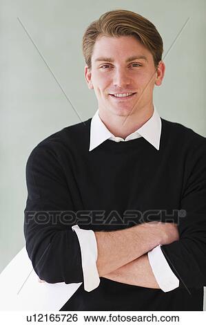 Stock Photograph - portrait of young teacher standing in front of blackboard. Fotosearch