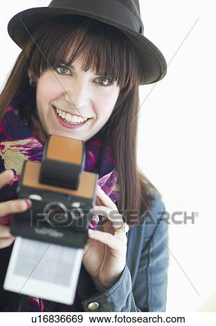 Stock Photo - Portrait of young woman with instant camera. Fotosearch