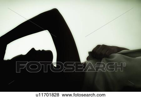 Stock Photo - Profile of young woman lying in bed . Fotosearch