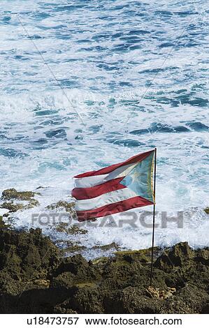 Stock Photo - Puerto Rico, Old San Juan, flag of Puerto rice on sea coast. Fotosearch