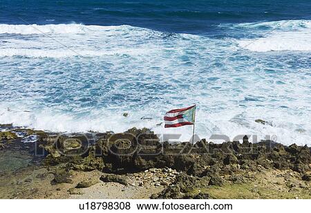 Stock Photo - Puerto Rico, Old San Juan, flag of Puerto rice on sea coast. Fotosearch