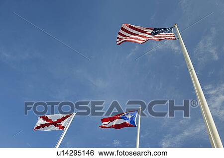 Stock Photograph - Puerto Rico, Old San Juan, low angle view of flags under blue sky. Fotosearch