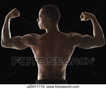 Stock Photography - Rear view of muscular man flexing muscles. Fotosearch