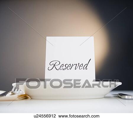 Stock Image - Reserved sign on place setting, studio shot. Fotosearch