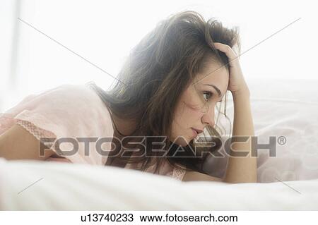 Stock Image - Sad young woman daydreaming . Fotosearch