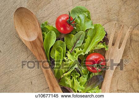 Stock Photography - Salad leaves and wooden spoon and fork. Fotosearch