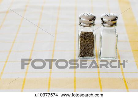 Salt and pepper shakers on checked tablecloth View Large Photo Image Picture - Salt and pepper shakers on checked tablecloth. Fotosearch
