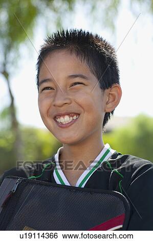 Stock Photograph - School boy (12-13) with bag, smiling. Fotosearch
